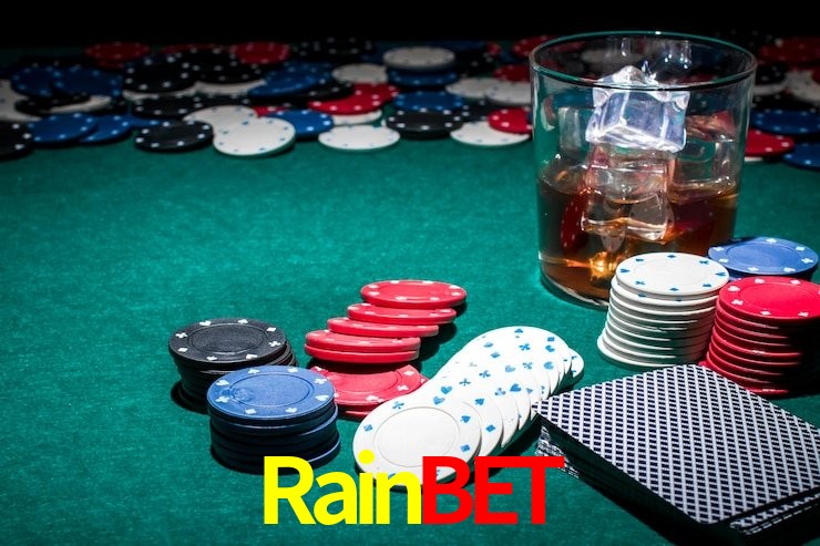 Escena dinámica inspirada en casino con iluminación Rainbet, cartas, fichas e íconos de juegos digitales en un espacio moderno de juegos.